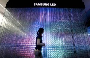 Një punonjës i Samsung Electronics kalon pranë baterive me ndriçim LED të shfaqur për vizitorët në një sallë ekspozite në selinë e kompanisë në Seul. /REUTERS