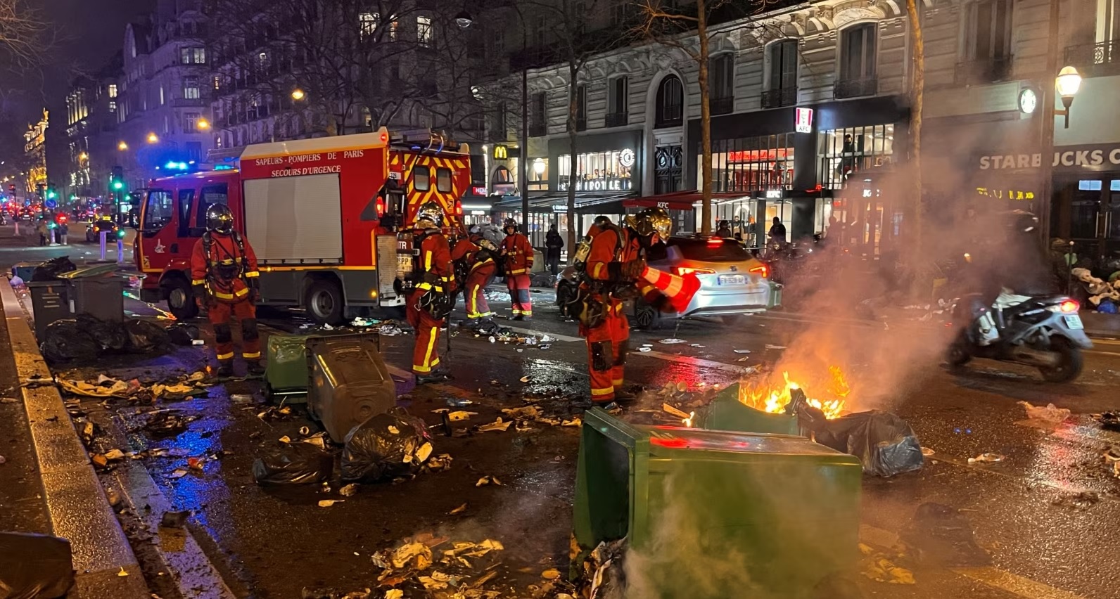 Zjarrfikësit francez duke shuar zjarrin e vënë nga protestuesit në Paris, më 20 mars 2023. Foto: Reuters