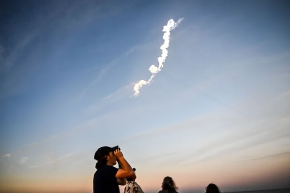 Njerëzit shikojnë nisjen e një rakete SpaceX Falcon 9 që mbante 21 satelitë të gjeneratës së dytë Starlink në Qendrën Hapësinore Kennedy të NASA-s, më 27 shkurt 2023. Foto: AFP