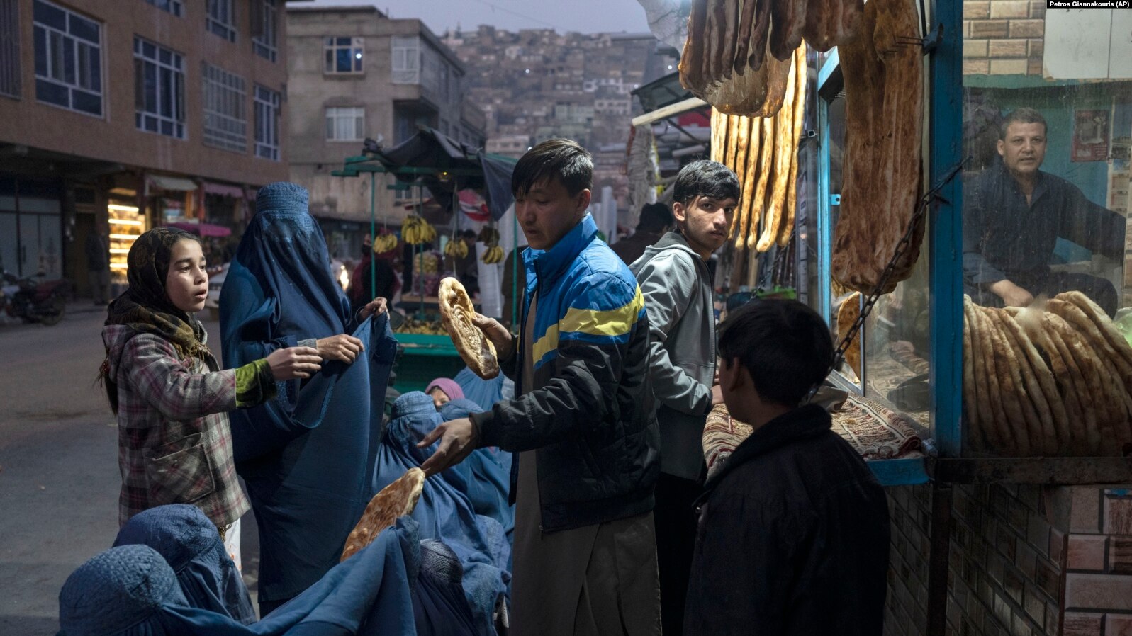 Një burrë u ndan ushqim disa njerëzve në Kabul, Afganistan. Foto: AP