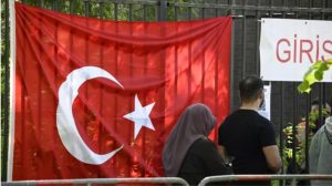 Votuesit turq kalojnë një flamur turk ndërsa bëjnë rrugën për në qendrën e votimit në konsullatën turke në Berlin më 9 maj 2023.