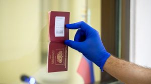 Një burrë duke e treguar pasaportën e tij në Ambasadën e Rusisë në Moldavi.
