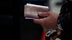Një qytetar duke mbajtur në dorë një pasaportë të Republikës së Kosovës.