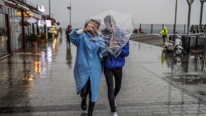 Një çift strehohet kundër shiut të madh me një çadër gjatë një dite stuhie në Stamboll, Turqi.