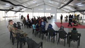 Refugjatë afganë duke dëgjuar një ligjëratë për sigurinë në Kampin Liya, në bazën amerikane Bondsteel, në Kosovë, më 7 tetor 2021.