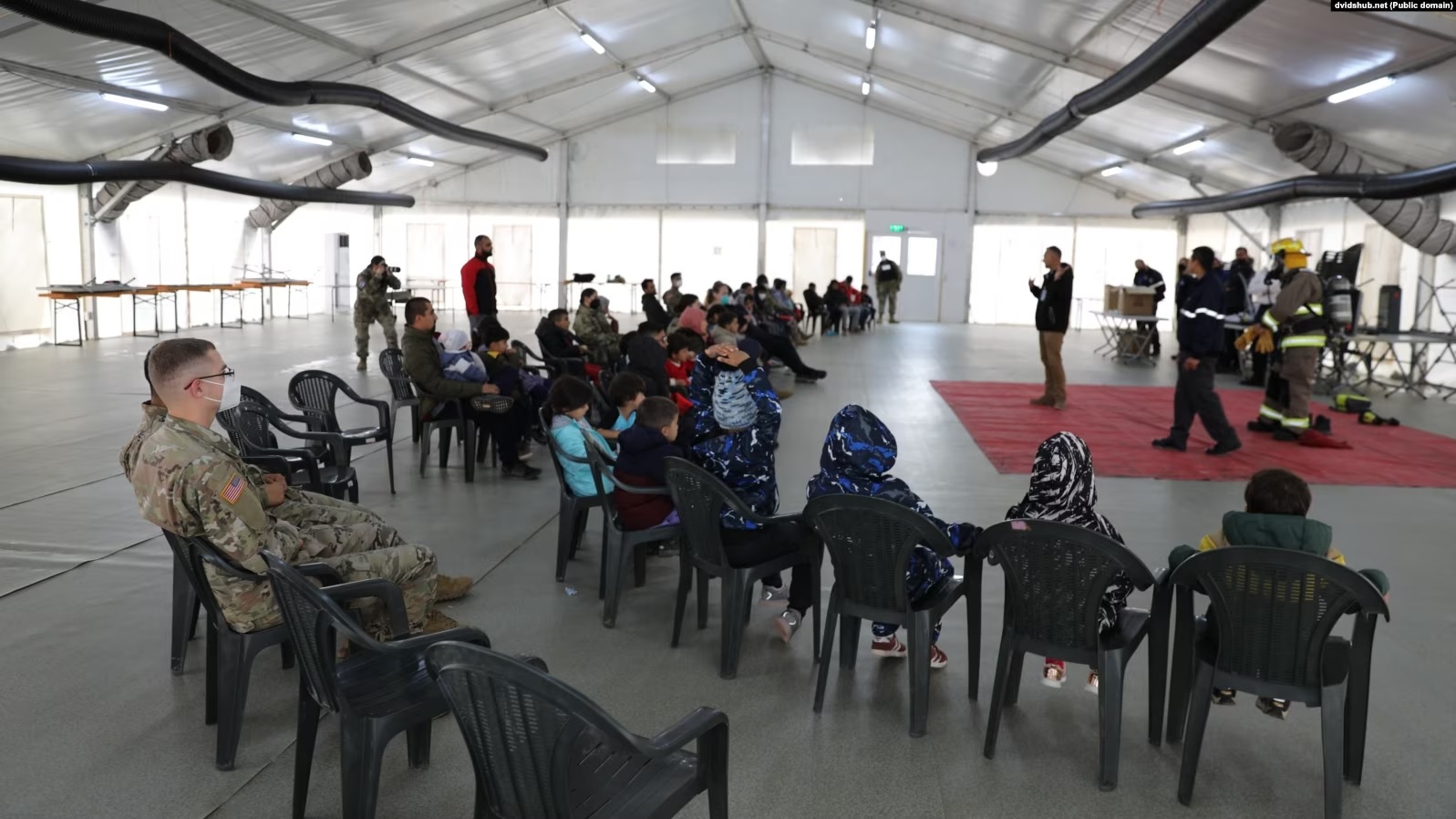 Refugjatë afganë duke dëgjuar një ligjëratë për sigurinë në Kampin Liya, në bazën amerikane Bondsteel, në Kosovë, më 7 tetor 2021.