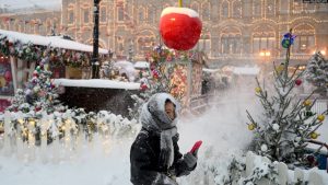 Një grua ec pranë tezgave të tregut në Sheshin e Kuq të mbuluar me borë në Moskë, 3 dhjetor 2023.