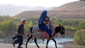 Një grua e mbuluar me burka dhe fëmijët e saj, duke udhëtuar me një gomar, në provincën afgane Badakshan. Tetor 2023.