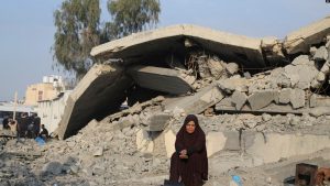 Një grua palestineze e zhvendosur nga bombardimet izraelite në Rripin e Gazës qëndron ulur pranë një shtëpie të rrënuar në Rafah, 27 dhjetor 2024.