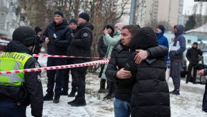 Zyrtarë policorë dhe disa banorë të mbledhur afër një zone të sulmuar në Ukrainë më 23 janar.