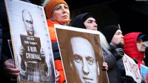 Protestuesit duke mbatur forografi të Vladimir Putinit dhe Aleksei Navalnyt gjatë një tubimi para Konsullatës Ruse në Nju Jork, pas njoftimit për vdekjen e kritikut të Kremlinit më 16 shkurt.
