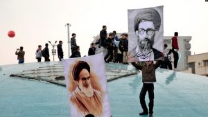 Dy djem duke mbajtur fotografitë e liderit suprem Ayatollah Ali Khamenei, në të djathtë, dhe themeluesit të Republikës Islamik Ayatollah Khomeini, majtas, gjatë marsheve të mbajtura në Teheran më 11 shkurt.