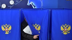 Një burrë duke dalë nga kabina e votimi, para se ta hedhë votën në kutinë e votimit në Novosibirsk, Rusi, 15 mars 2024.