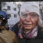 Një grua shikon një nga fotografitë e ekspozitës "Ukraina: Një krim lufte", që u hap në Prishtinë më 29 prill 2024.