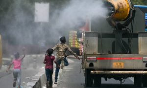 Fëmijët vrapojnë pas një kamioni që spërkat ujë përgjatë një rruge në Nju Delhi, ndërsa qyteti regjistron një temperaturë rekord prej 49.9C. Fotografia: Arun Sankar/AFP/Getty Images